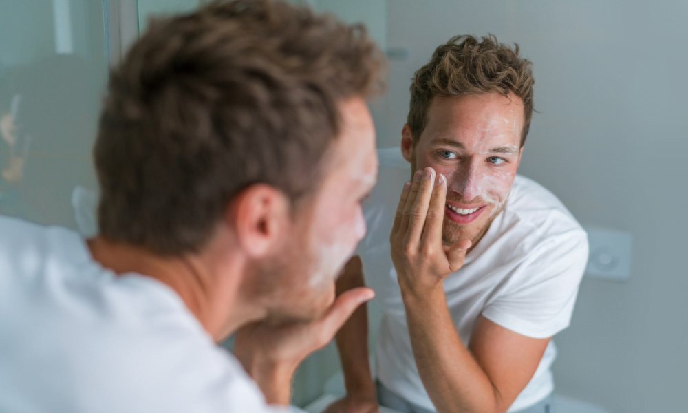 young-man-using-face-cleanser-face-wash-mirror-1000x600